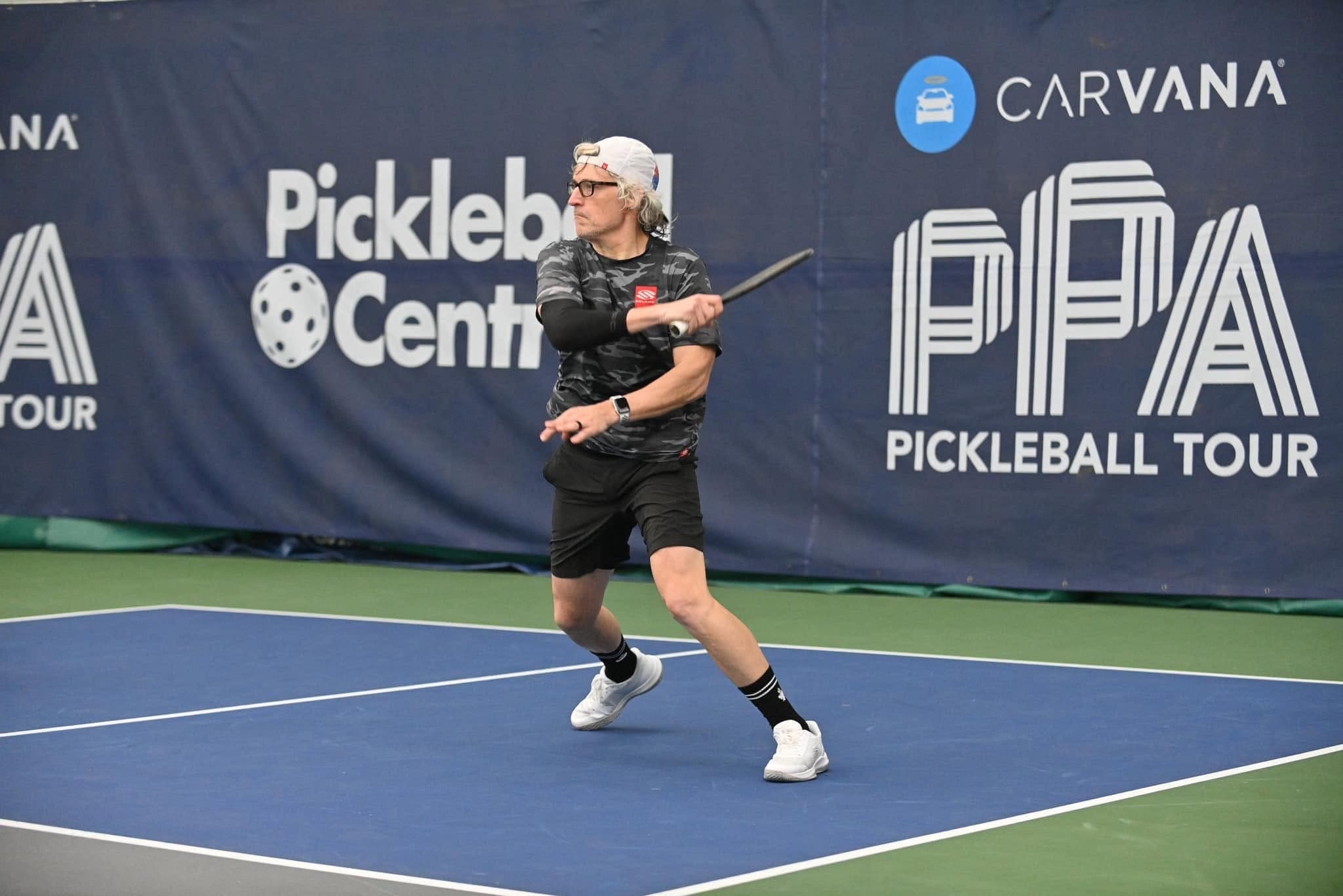 Chad Flynn mid-forehand in front of a PPA Pickleball Tour and Pickleball Central tournament backdrop