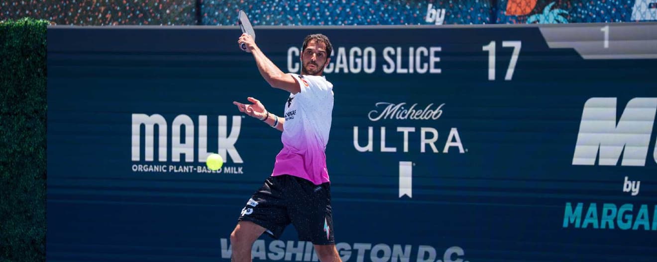 Mo Alhouni mid-forehand in a white-and-pink gradient jersey, MLP Chicago Slice scoreboard backdrop with MALK and Michelob Ultra sponsors